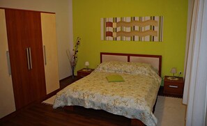 A bedroom with a bed, nightstands, a wall art piece, and a door. - Amazing Place 4 Peaceful Holiday Apartman PIA (Poljana)