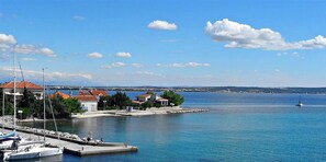 A marina with boats, a lighthouse, and buildings along the waterfront. - Amazing Place 4 Peaceful Holiday Apartman PIA (Poljana)