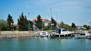 A marina with boats docked, a clear sky, and buildings in the background. - Amazing Place 4 Peaceful Holiday L (Preko)