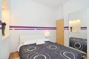 A bedroom with a bed, a nightstand, a mirror, and a wardrobe. - Amazing Place 4 Peaceful Holiday L (Preko)