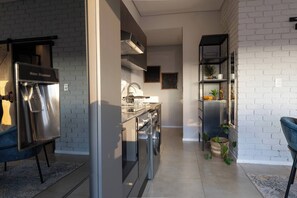 Una cucina moderna con elettrodomestici in acciaio inossidabile, un dispenser d'acqua e un forno integrato.