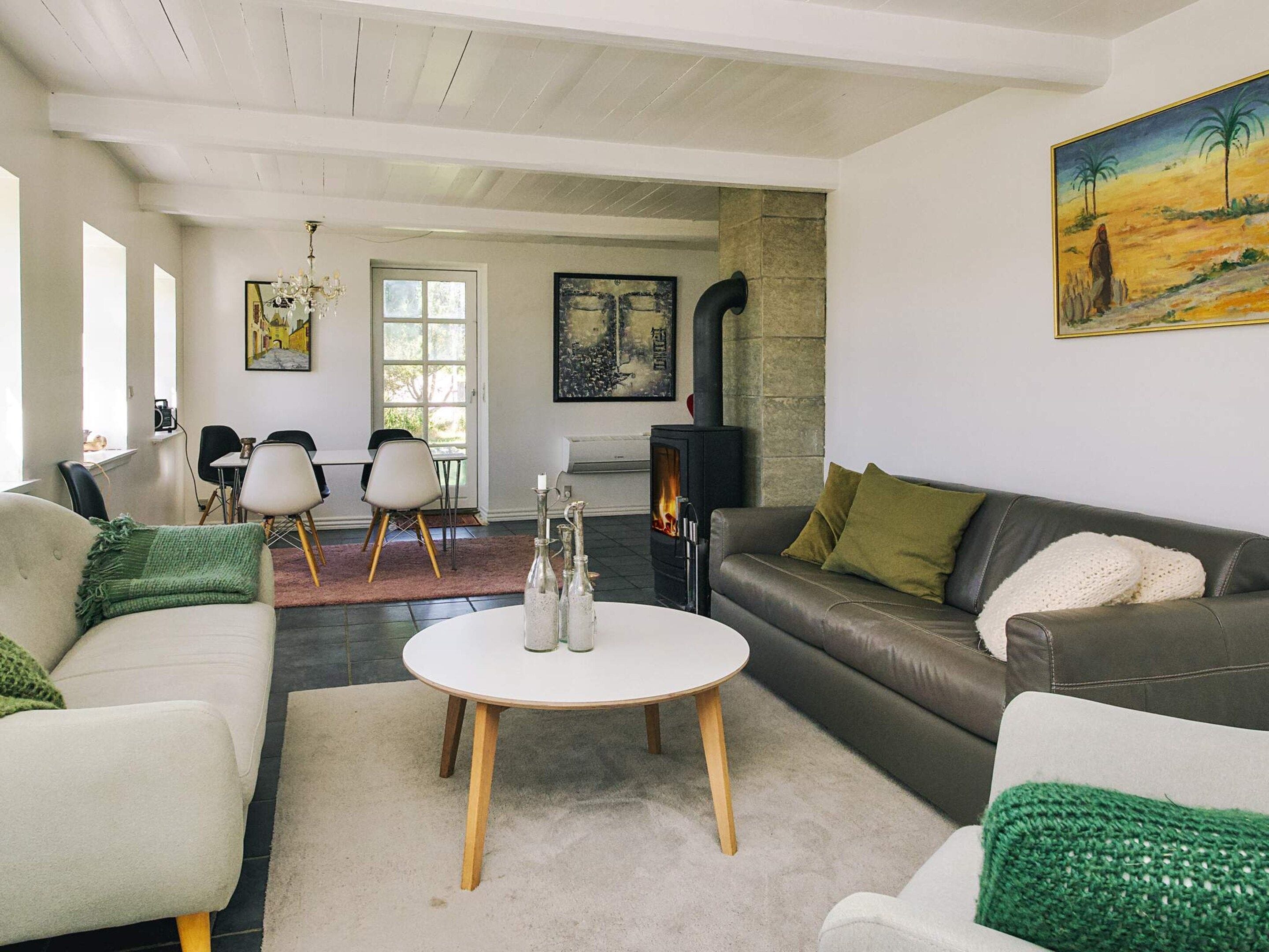 Una sala de estar con chimenea, un comedor y obras de arte en las paredes.
