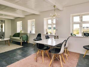 A dining area with a table, chairs, and a chandelier.