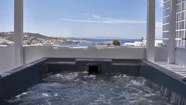 Un bain à remous avec vue sur une ville côtière et la mer.