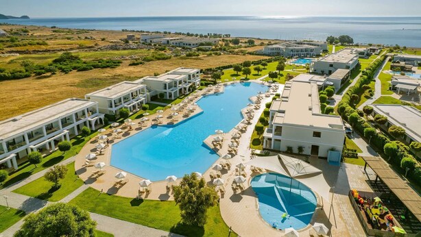 A resort with a large pool, multiple buildings, and a view of the sea. - Levante Athletic Resort (Rhodes)