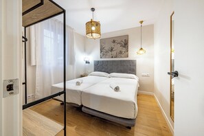 Ein Schlafzimmer mit einem Doppelbett, einem großen Spiegel, einem Deckenventilator und einer Wandleuchte.