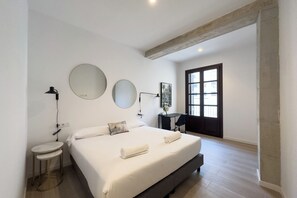 A modern bedroom with a large bed, two bedside tables, a desk, and a large window. - 2 Bedroom apartment - Two Bedroom Apartment, Sleeps 4 (Barcelona)