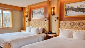 A hotel room with two beds, wooden headboards, a large window, and framed pictures on the walls. - Inviting 2 Queen Room w/ Balcony | Sauna & Hot Tub (Banff)