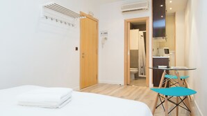 A hotel room with a bed, a desk, and a chair. - Ample Bolsa estándar tipo 1 (Barcelona)