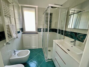 A bathroom with a shower, sink, and toilet. - The Marilena Penthouse (Capri)
