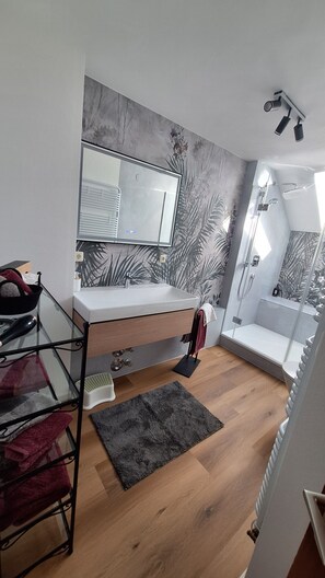 A compact bedroom with a bunk bed, a bedside table, a mirror, a shower, and a small rug. - "Panorama" Maisonette Apartment with 2 Balconies (Freiamt)