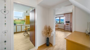 A modern interior with a kitchen, dining area, and a view through a window. - "Panorama" Maisonette Holiday Apartment with 2 Balconies (Freiamt)