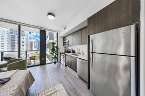 Eine moderne Küche mit Edelstahlgeräten, ein Essbereich mit Aussicht und ein Balkon mit Stadtblick.