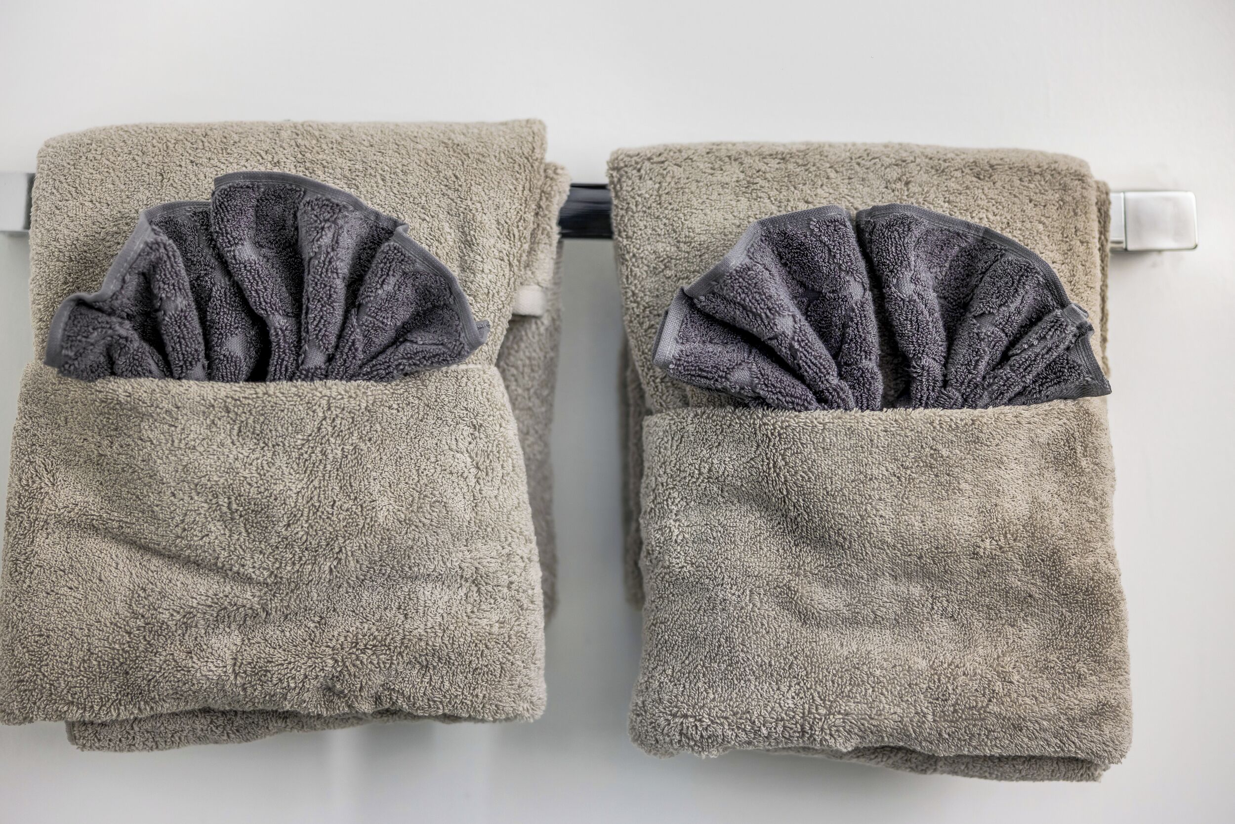 Two towels with folded towels in their pockets.