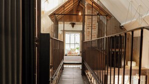 A corridor with a skylight, wooden beams, and a metal railing. - Artist barn near Châtelaudren (Plélo)