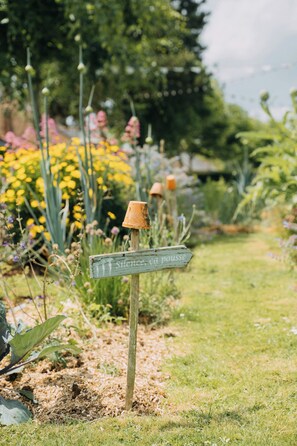 Ein Gartenweg mit einem hölzernen Wegweiser und einer rustikalen Laterne.