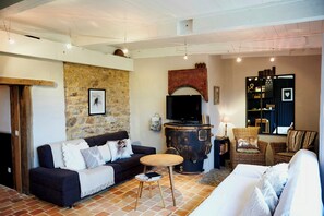 Ein Wohnzimmer mit Steinwand, Fernseher, Kamin und Bücherregal.