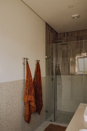 A modern bathroom with a glass shower enclosure, a towel rack with two towels, and a speckled tile wall. - Franschhoek Holiday Home for a family or friends traveling together (Franschhoek)