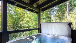 A hot tub with a view of a forested area. - Lakeside Rendezvous (Gatlinburg)