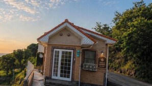 A small brick building with a tiled roof, a door, and a sign that reads 'Villa Amoria.' - Peaceful Ocean View Villa with Free Parking & Full Kitchen (Miyazaki)