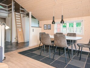 Un interior moderno con comedor, techo de madera y vistas al exterior.