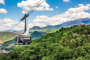 A cable car suspended over a forested mountain landscape. - Still Waters Studio (Gatlinburg)