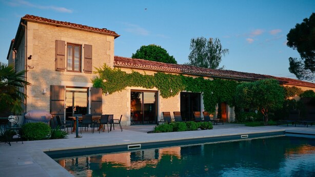 A two-story building with a swimming pool, outdoor seating, and a covered patio. - Ideal for families, couples and relaxing holidays, swimming pool, quiet, authentic. (Julienne)