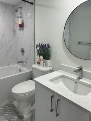 Un baño moderno con bañera, inodoro y lavamanos.