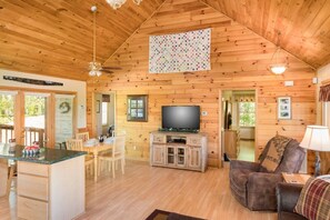 A wooden cabin interior with a dining area, a television, and a cozy living space. - A Heavenly View (Sevierville)