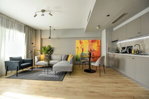 A modern living room with a sofa, chairs, a coffee table, a floor lamp, and a large abstract painting. - Apartment in Prime Central Location (Bucharest)