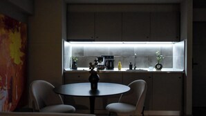 Une cuisine moderne avec une fenêtre, une table à manger et des chaises.