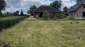 Een landelijk gelegen bezit met een stenen huis, een omheind gebied en een heldere lucht.