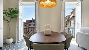 A dining area with a round table, chairs, a potted plant, and a hanging light fixture. - Spacious Apartment in Granada Center San Anton 204 (Granada)
