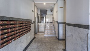 A hallway with a marble floor, a staircase, and a wall with filing cabinets. - Plaza de Castilla II (Madrid)