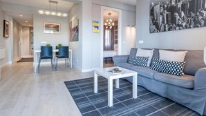 A modern living room with a grey sofa, a white coffee table, and a black and white patterned rug. - Plaza de Castilla II (Madrid)