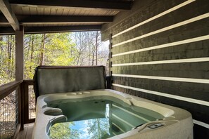 A hot tub with a wooden deck and a view of trees. - Trail's End (Gatlinburg)