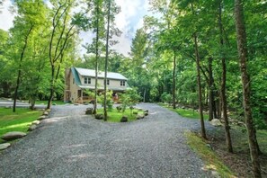 A house surrounded by a gravel driveway and trees. - Cork's Creekside (Cosby)