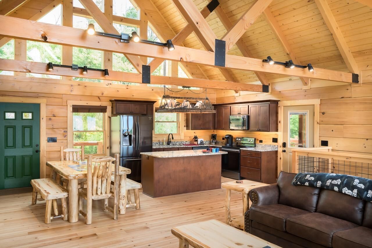 A spacious wooden cabin with a large kitchen, dining area, and a cozy living room.