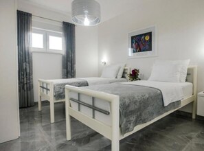 A modern bedroom with two beds, a large window with curtains, a painting on the wall, and a hanging light fixture. - Villa Antonija With Outdoor Pool (Imotski)