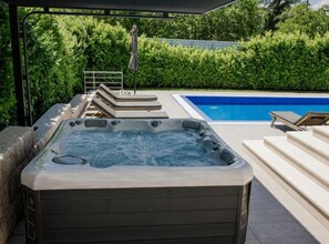 A hot tub with a pool and lounge chairs in a garden setting. - Villa Antonija With Outdoor Pool (Imotski)