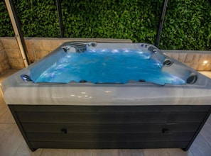 A hot tub with a clear water surface, surrounded by a tiled floor and a stone wall. - Villa Antonija With Outdoor Pool (Imotski)