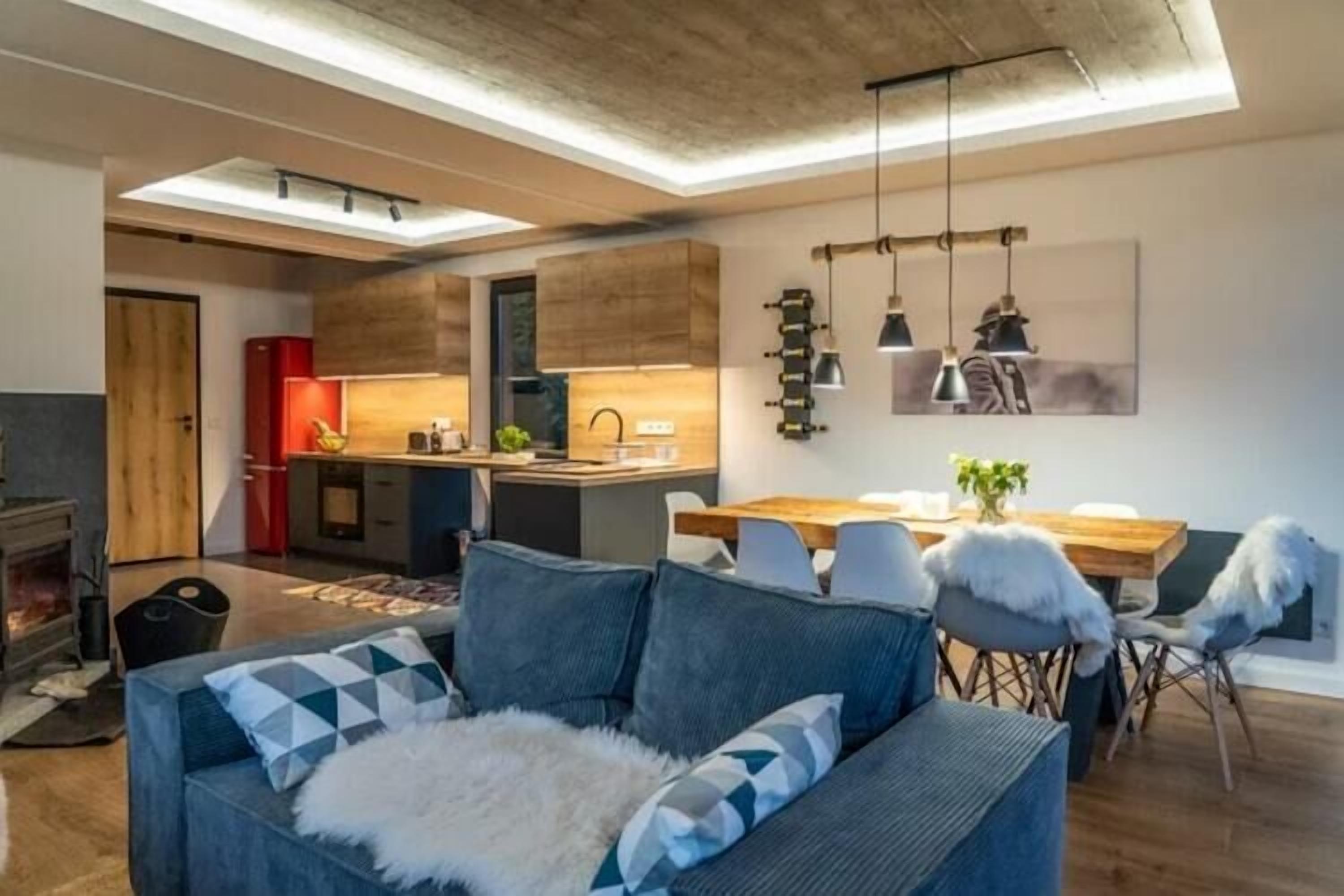Un salon moderne avec un canapé, une table à manger et une cuisine en arrière-plan.