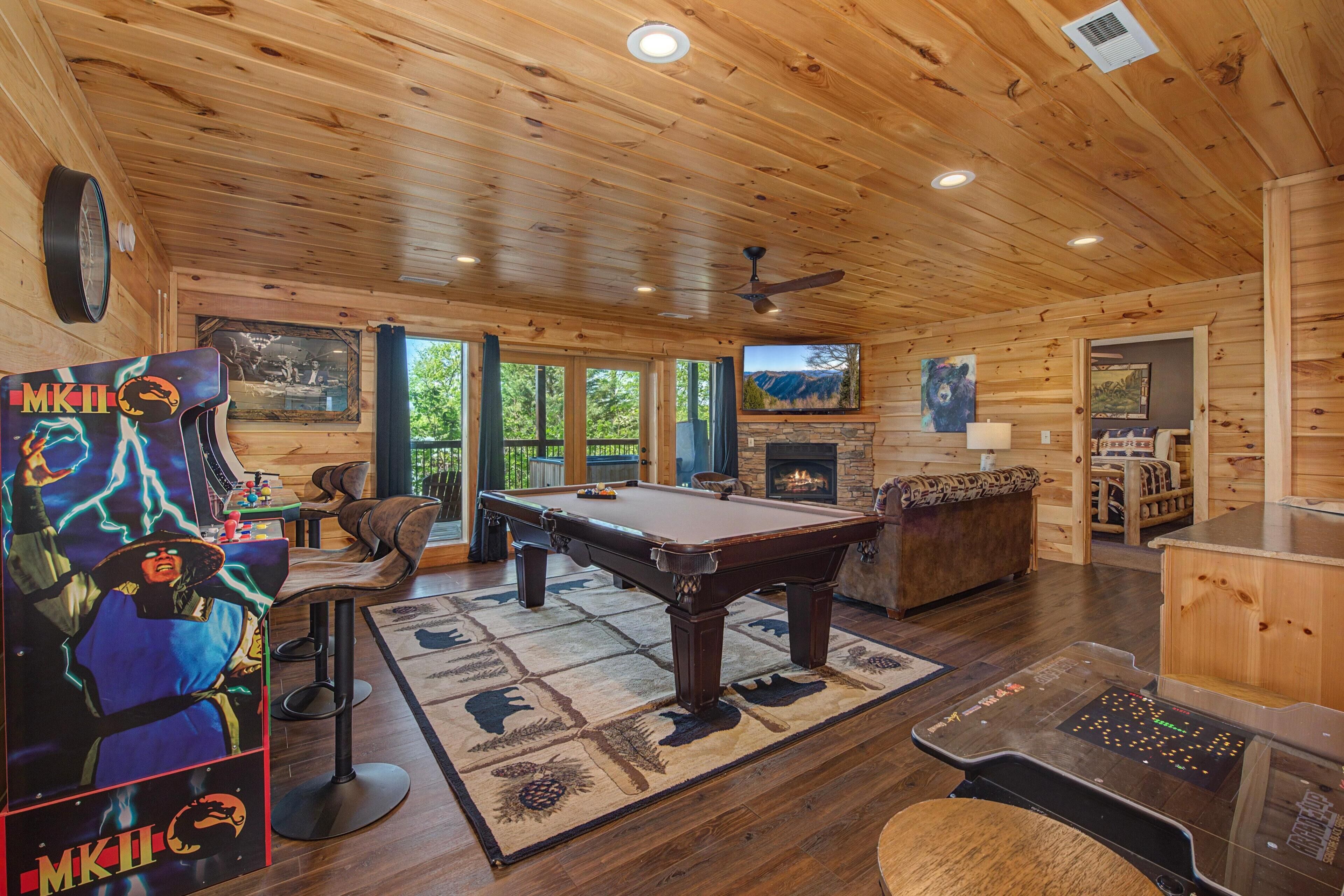 A wooden interior with a pool table, a fireplace, and a bear painting.