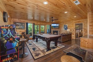 A wooden interior with a pool table, a fireplace, and a bear painting. - Another Day in Bearadise (Gatlinburg)