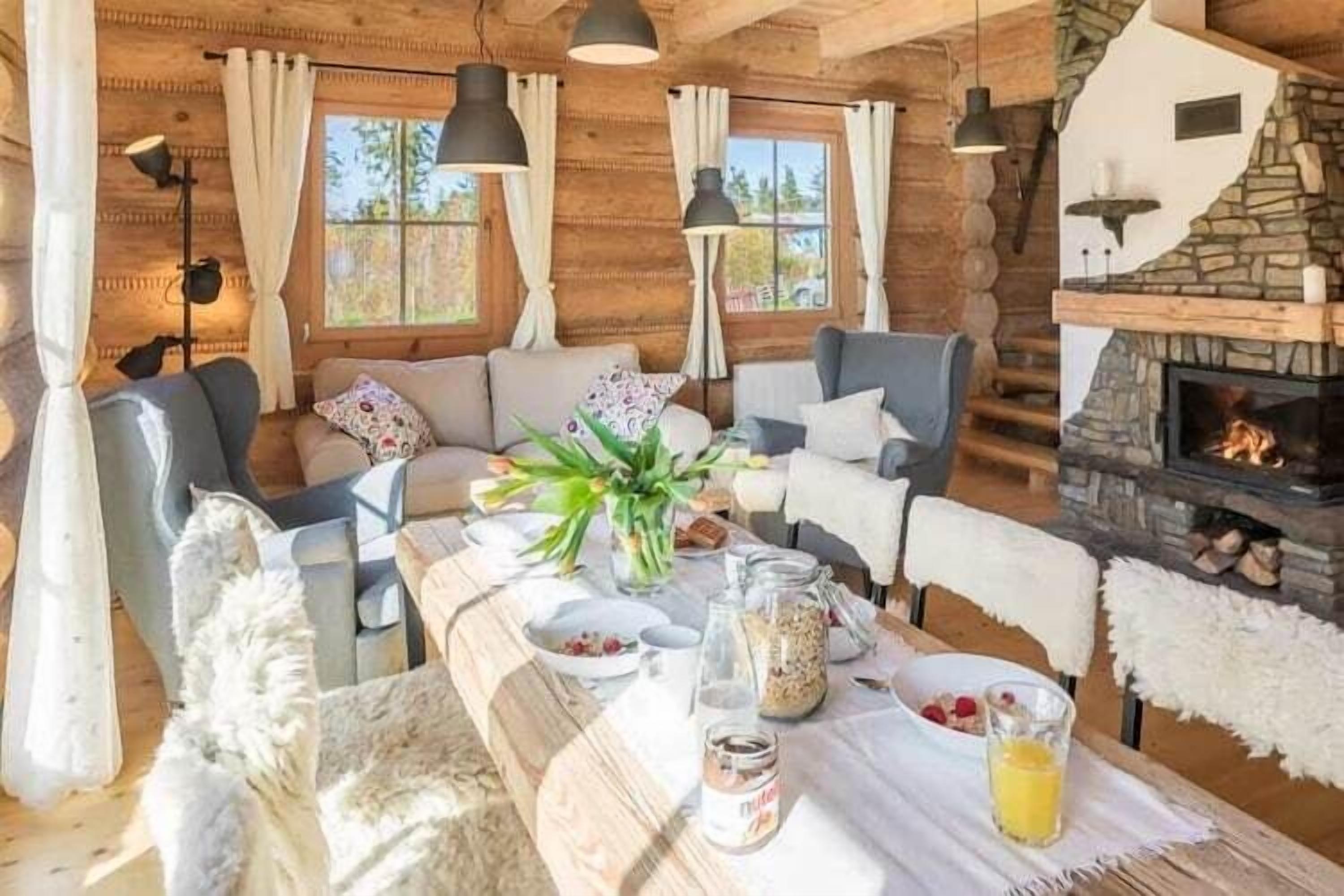 L’intérieur d’un chalet confortable, avec une table à manger dressée, une cheminée et un canapé.