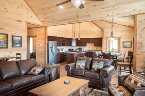 Un interior de cabaña espacioso con sala de estar, comedor y cocina.