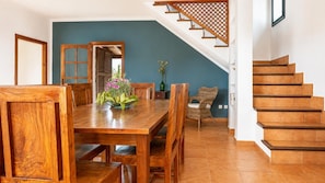 A wooden dining table with chairs, a vase of flowers, and a staircase with wooden steps. - Villa Sa Pleta - Three Bedroom Villa, Sleeps 6 (Mallorca)