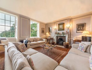 A spacious living room with a fireplace, a sofa set, and a coffee table.
