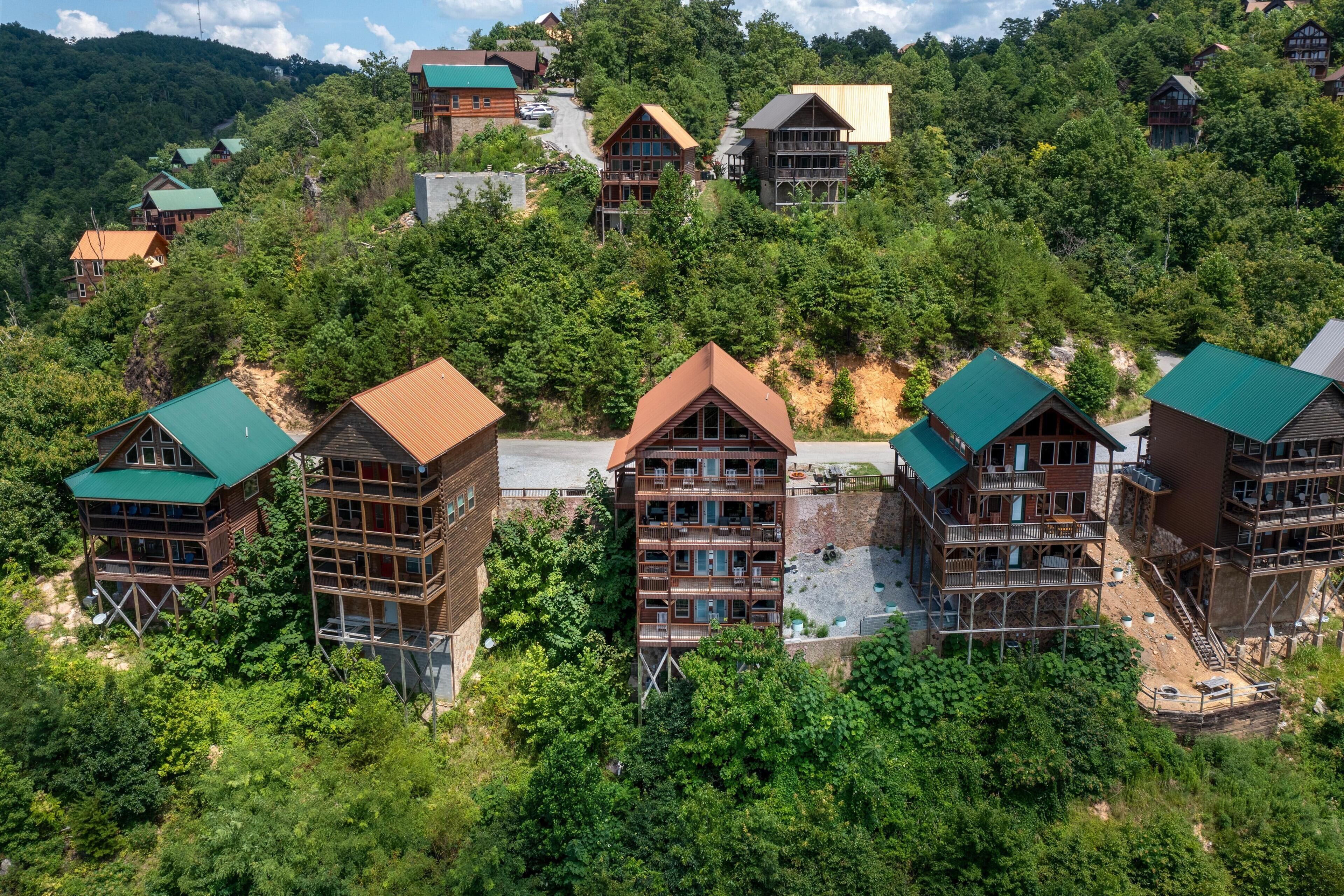 Un conjunto de cabañas de madera con varios pisos y balcones, rodeadas de un bosque denso.
