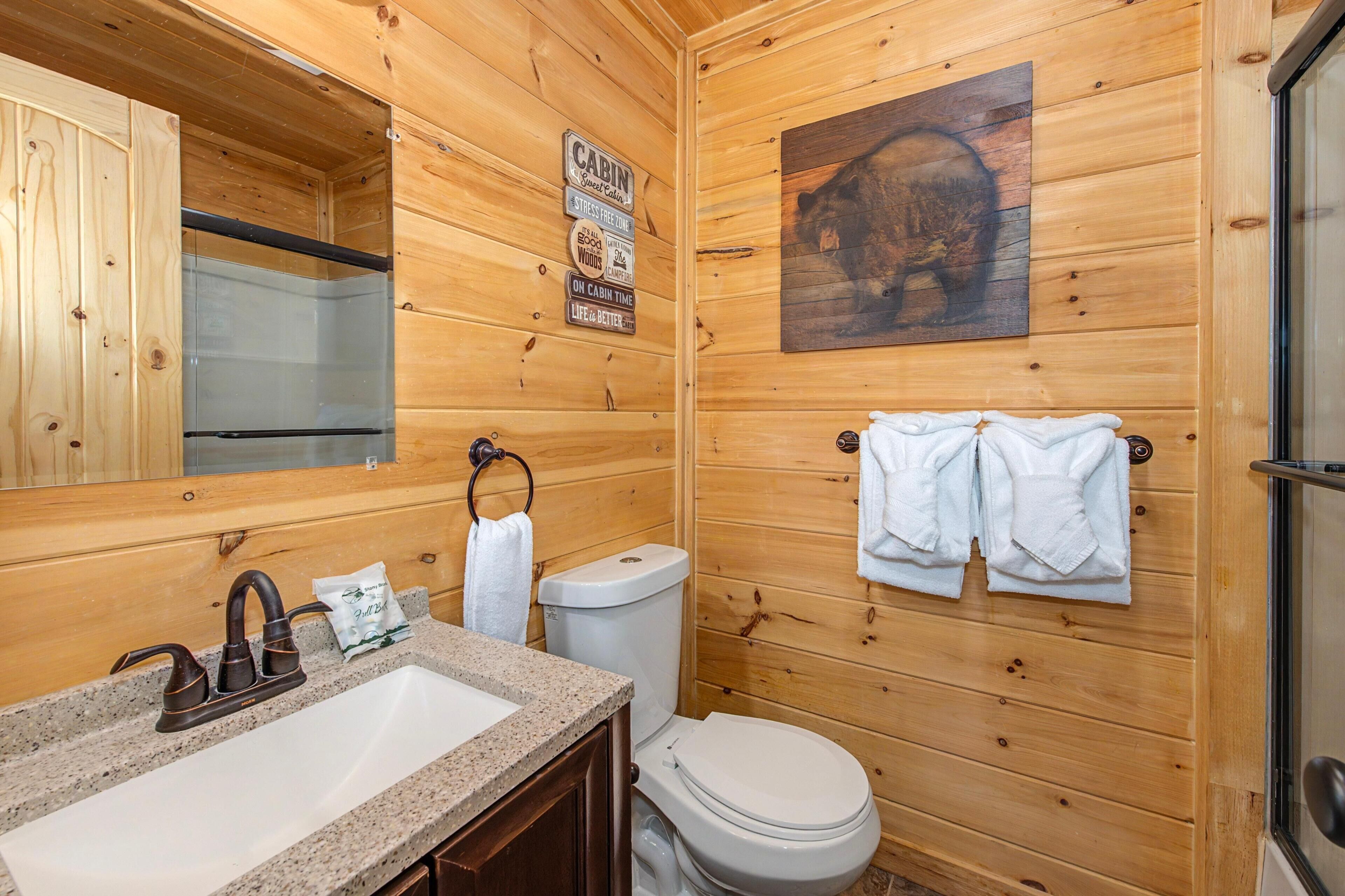 Ein Badezimmer einer Holzhütte mit Waschbecken, Toilette und Handtuchhalter.